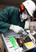 Photo d'un des employés de Solidarité Technologique en train de démanteler une unité centrale.